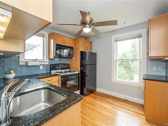 The kitchen, has 2 windows, a gas stove, a new refrigerator, under cabinet lighting, dishwasher, and a microwave.
