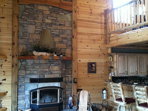 Stone wood-burning fireplace in living room.