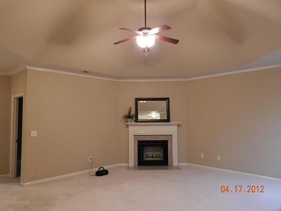 Living room with vaulted ceiling and wood burning fireplace.