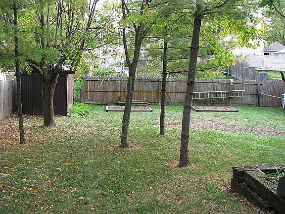 Large back yard, fenced with storage shed, enclosed patio, small garden area.