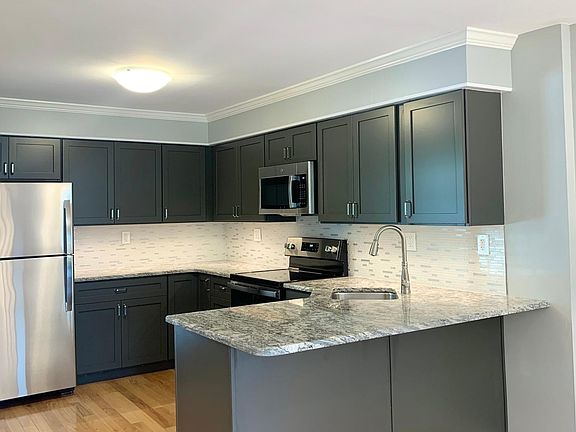 Brand new sparkling kitchen with granite countertops, glass tile backsplash and stainless steel appliances