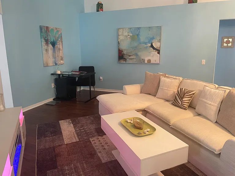 Comfortable living room with a sectional sofa, coffee table, and a dedicated desk nookideal for relaxing or remote work.