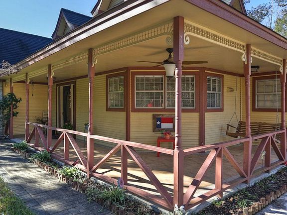 Cute covered wrap around front porch with gingerbread detailing and two tone paint.