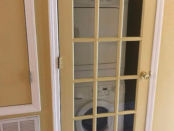 Stacked laundering equipment tucked away in hall closet.
