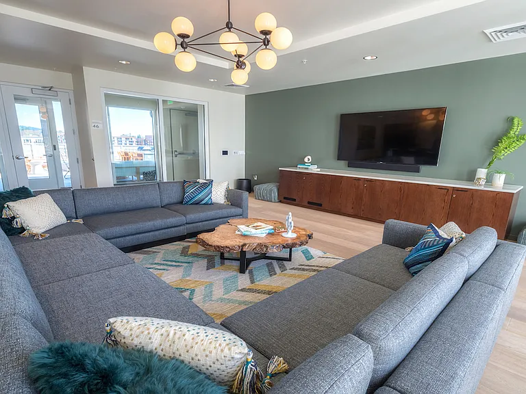 Entertainment lounge with sectional seating and TV setup.