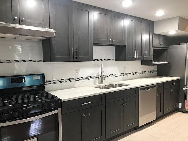 Kitchen with quartz counter-top and tiled backsplash