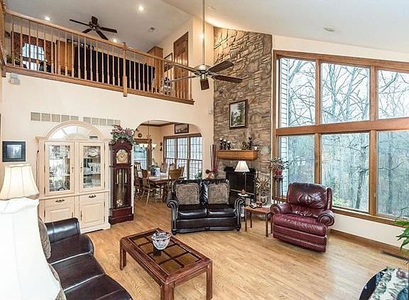 Vaulted great room w/ full stone masonry fireplace and half wall of windows.  Arched doorway leads to breakfast room.
