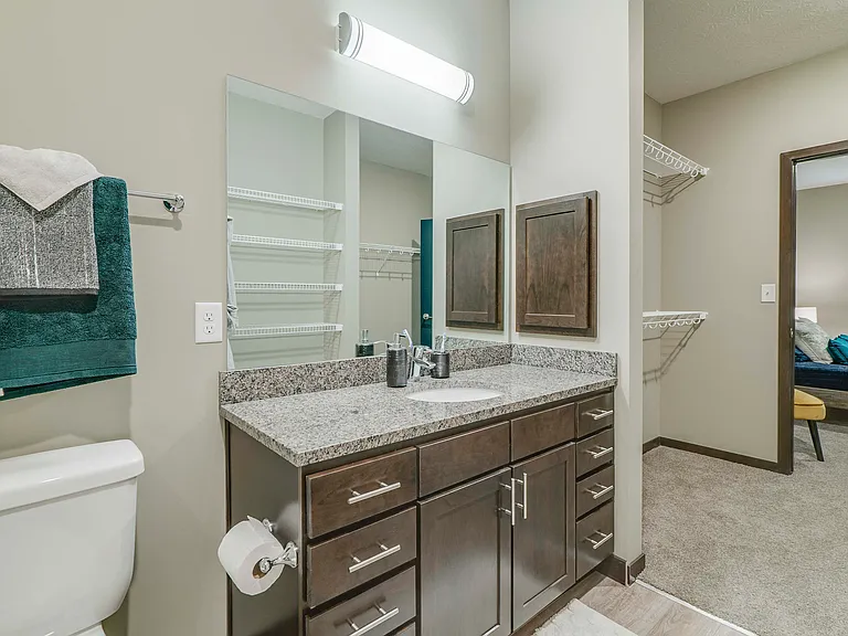Get ready for the day in a sleek bathroom with a granite countertops and stainless steel fixtures.