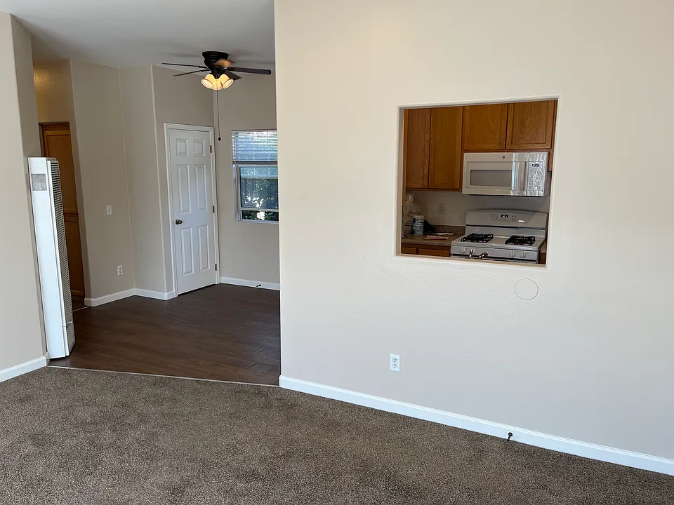 Kitchen looks into large living room with fireplace