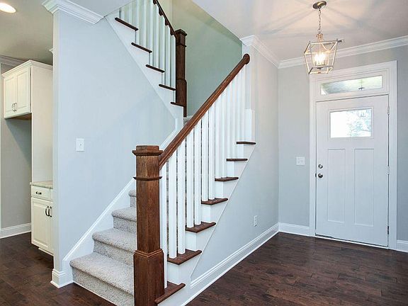 Front entry with stairs and start of kitchen to the left.