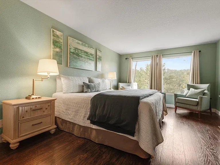 Master bedroom suite with beautiful hardwood floors and plenty of light large closet space and comfortable side chairs and views of the beautiful Monterey pines.