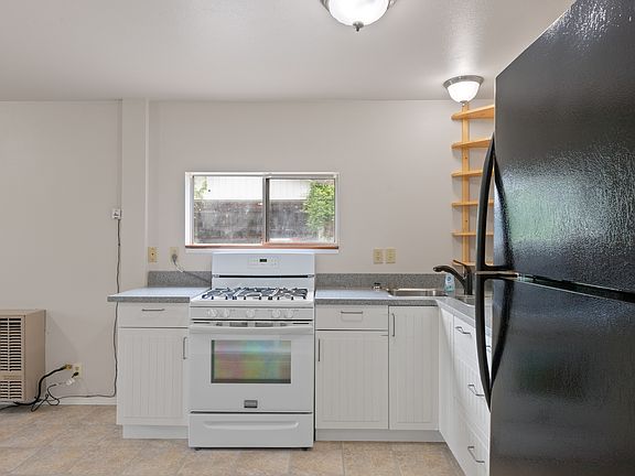 It's really a cute kitchen with a window to the yard and a handy corner rack.