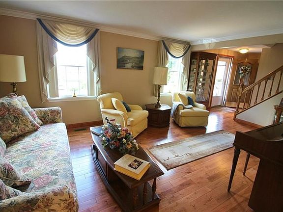 A gracious living room with crowne molding and  hardwood floors greets you from the foyer.