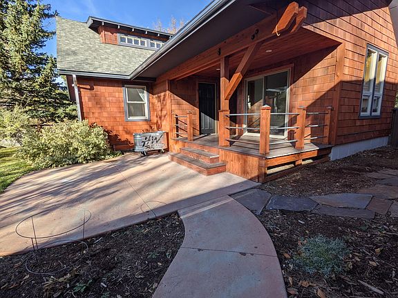 Fully fenced in backyard with a covered back deck, concrete patio and space to roam