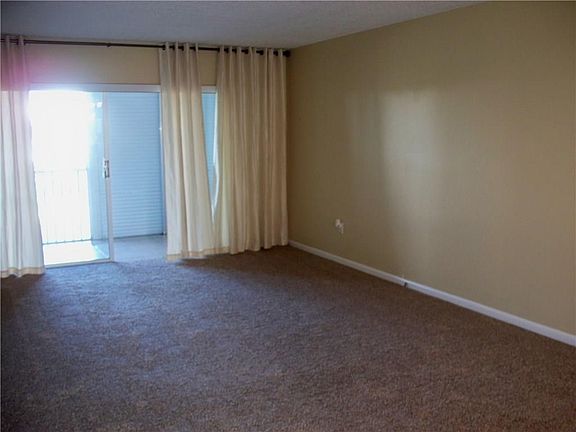 Living room with new carpeting and freshly painted throughout the unit