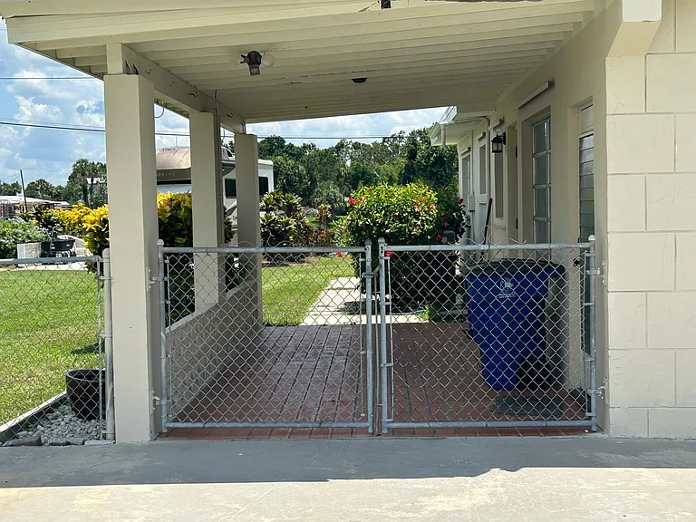 Side of home, behind gate. No parking beyond the gate.
