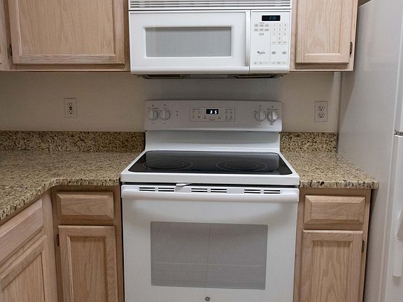 Granite counter tops clean cabinets microwave and flat top stove .