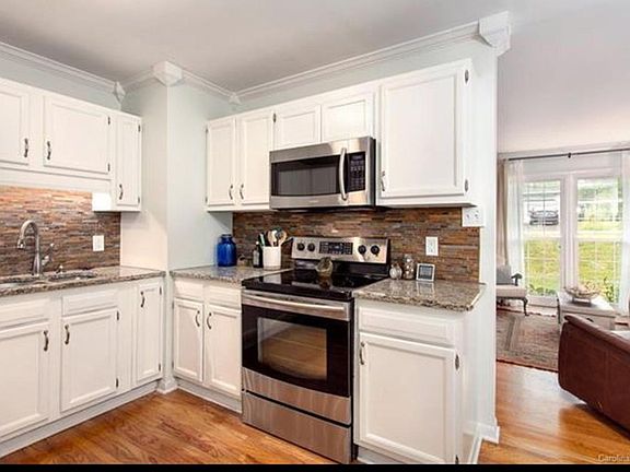updated kitchen. gas stove, side by side refrigerator, granite countertops and microwave
