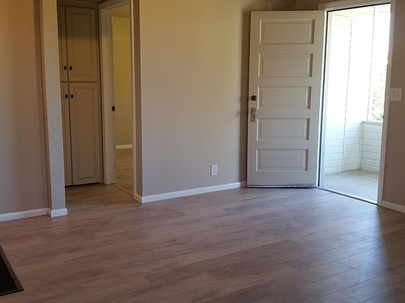 living room, front door to porch, linen closet and doorway into front bedroom, floor furnace lower left