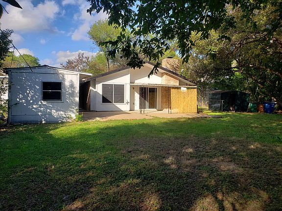 Back of house. Patio and large storage/work shed.