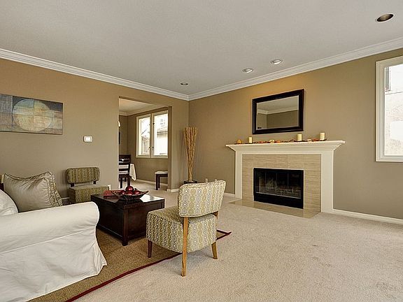 This spacious Living Room is warm & inviting and features a mantled fireplace.