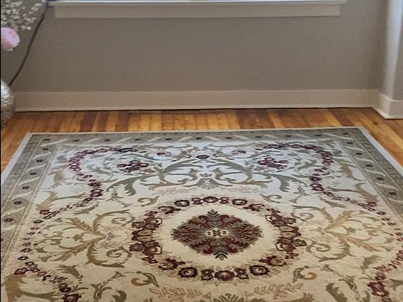 Bedroom showing beaming hardwood floors and an area rug. accommodates a king or queen sized bed nicely.