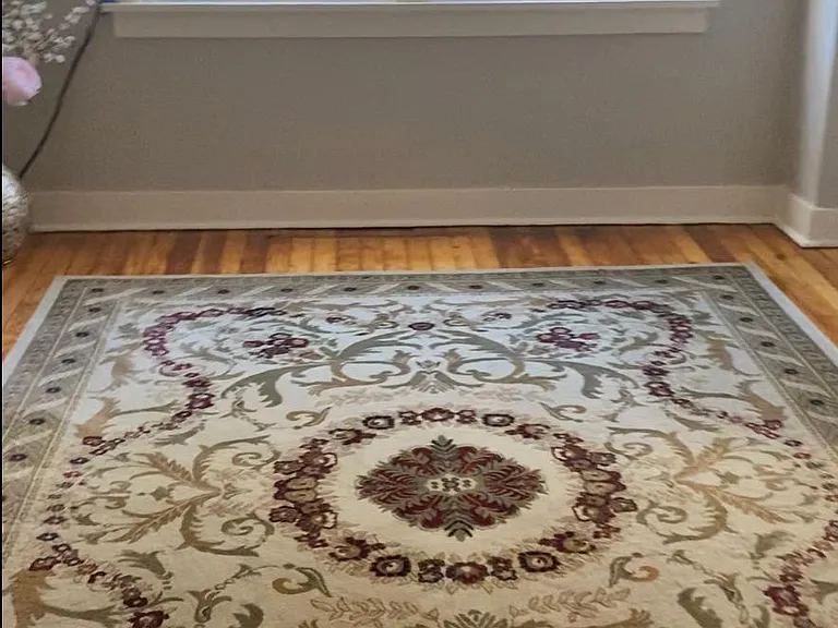 Bedroom showing beaming hardwood floors and an area rug. accommodates a king or queen sized bed nicely.