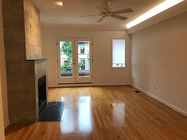 Living room with gleaming wood floors, working wood fireplace. And a tree level, deck looking over Swann St.