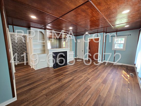 Bright and inviting living space with LED lighting, waterproof plank flooring, and black marble tile
