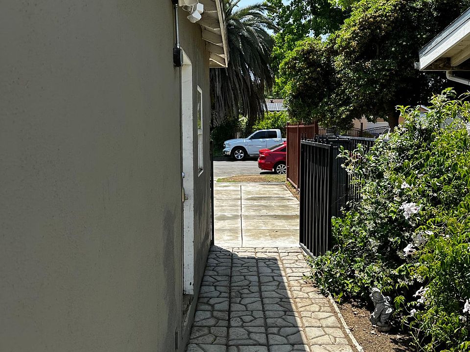 Side. 
Green. Paved. Strong LED floodlights all around the house. Extra security.