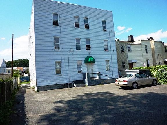 Backyard View. Apartment 1B is on the left of the building next to the driveway. Backyard parking (for compact cars only.)