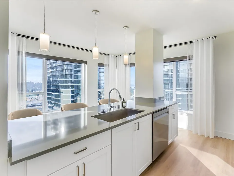 Renovated Package I kitchen with white cabinetry, grey quartz countertops, and hard surface flooring