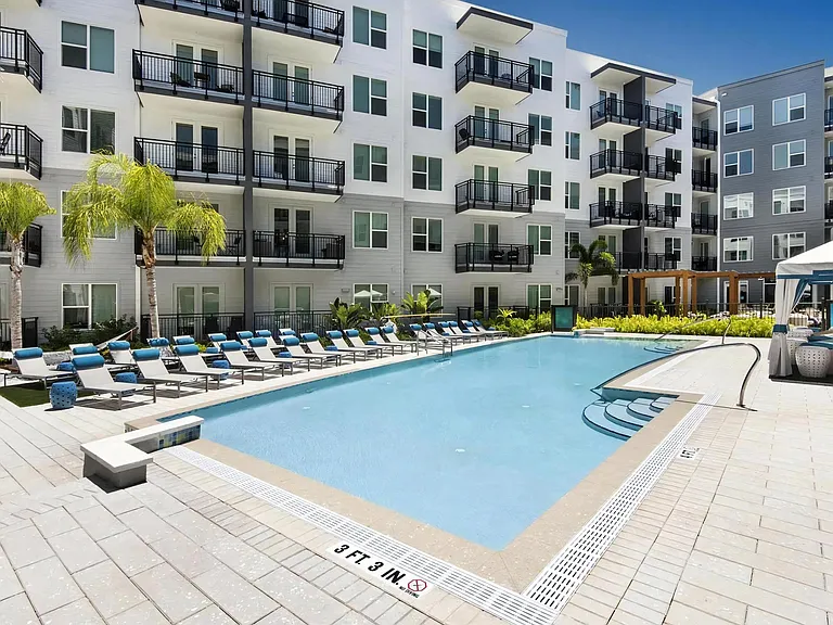 Sunny Pool Area with Comfortable Seating and Poolside Cabanas