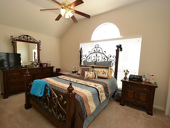 Bedroom offering raised ceilings, ceiling fan with light fixture, two inch window blinds and nice closet space.