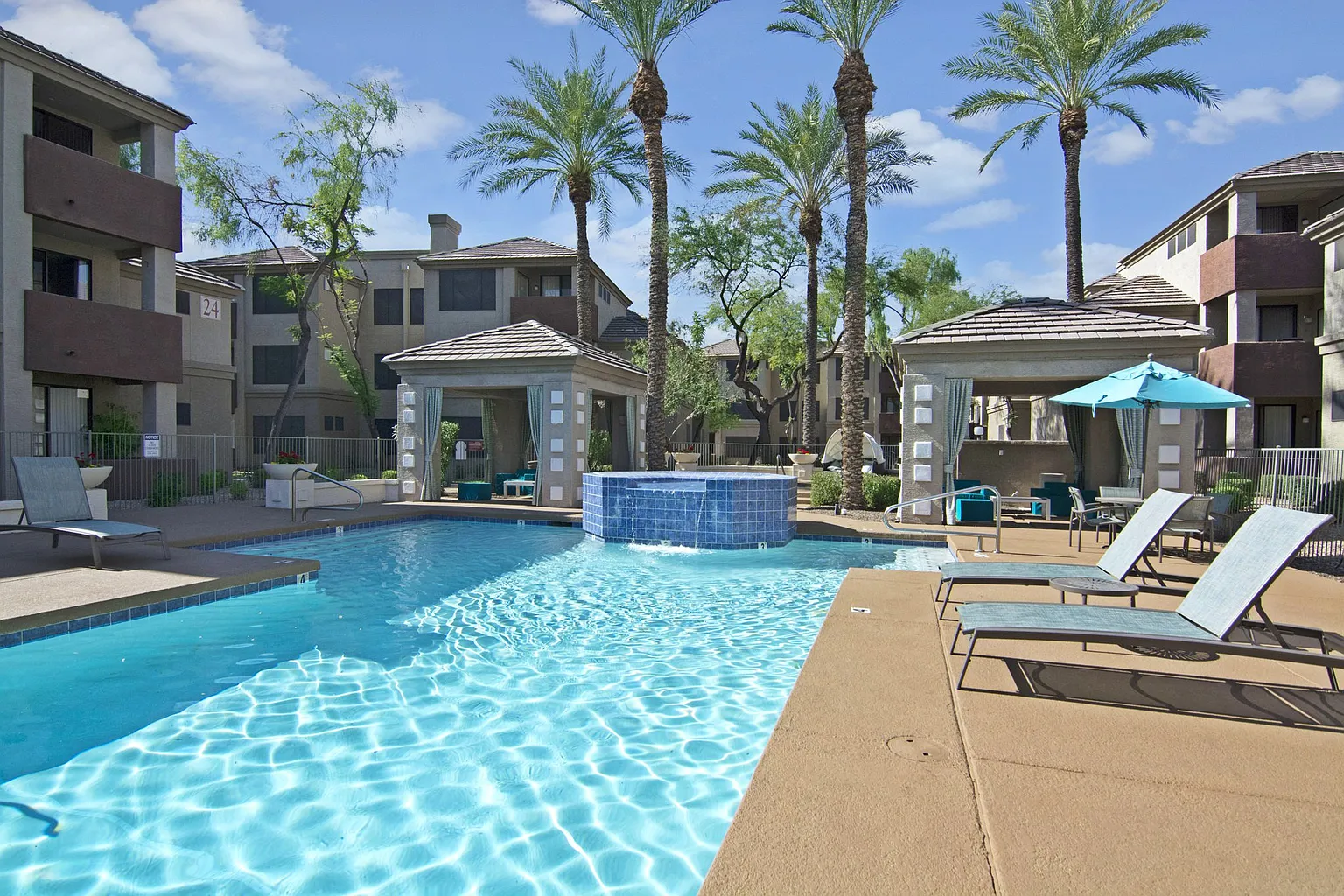 Resort-style swimming pool with a spa and lounge chairs.