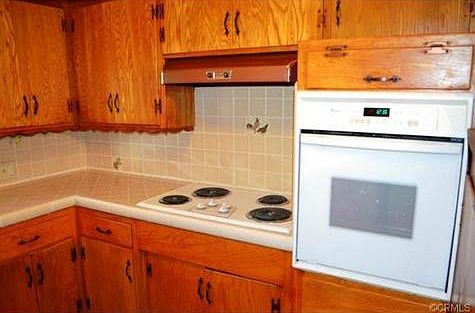 The kitchen has tile counter with updated appliances.