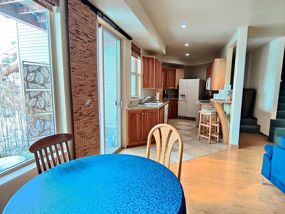 Large dining area next to kitchen and windows