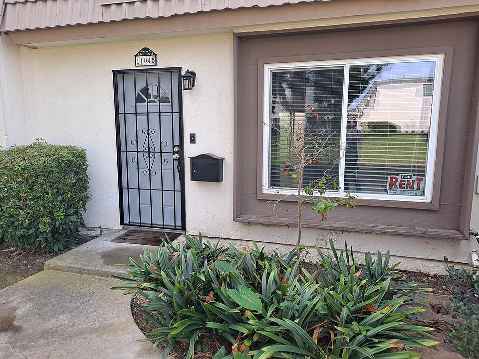 Front Entrance New Security Door and New Door. View of Grassy courtyard and Pine Trees.