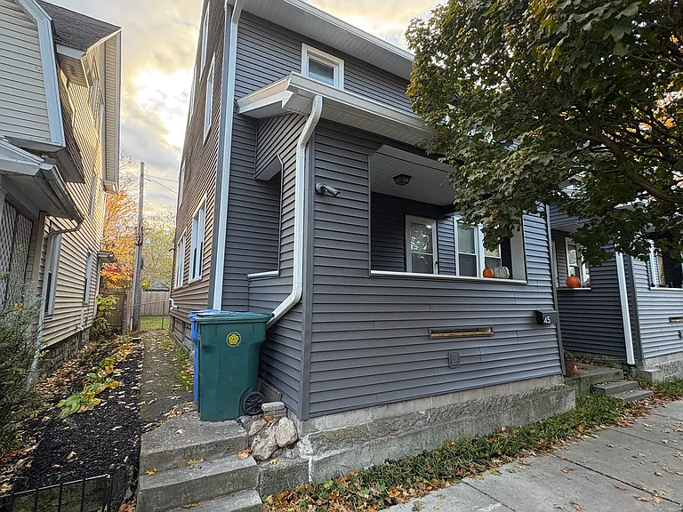 View of pathway adjacent to 45 Luzerne. A rear door is located in the back, which leads to the unit (basement/kitchen). Landscaping (up to neighboring house) is provided by landlord.