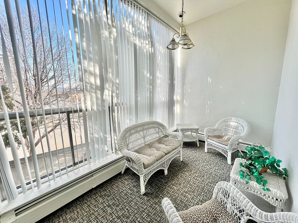 Relax in this charming sunlit space featuring elegant wicker seating.