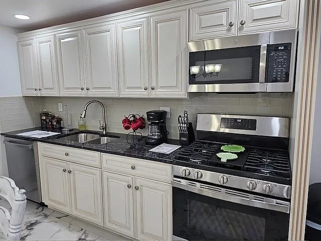 KITCHEN WITH NEW APPLIANCES AND GRANITE COUNTERTOP