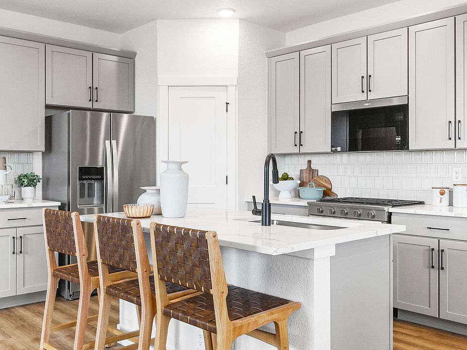 Elegant marble island and sleek gray cabinetry define this Falcon, Colorado kitchen.