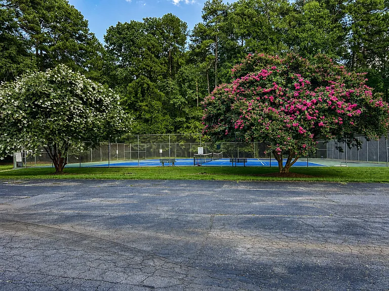 Tennis courts are part of the amenities package but are not adjacent to, nor visible from the listed property.