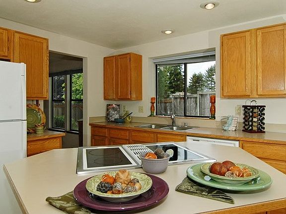 Kitchen overlooks deck & fenced yard.