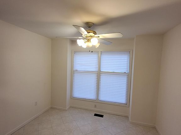 large dinette with 12x12 ceramic tile flooring and ceiling fan. Large enough for dining room-sized table