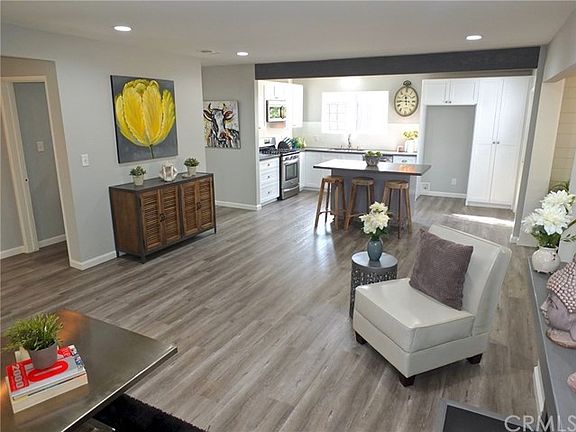 Welcome to open concept living! The exposed wood stained beam across the kitchen matches the custom 