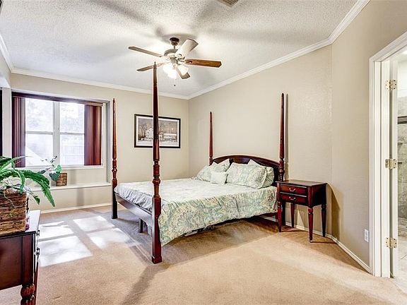 Spacious downstairs master suit with window seating. Bronze ceiling fan. Crown molding. French doors lead to an updated master bath.
