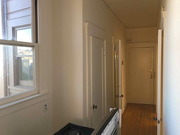 Hallway, with bench, entrance door at end, storage closet (with window) on left,