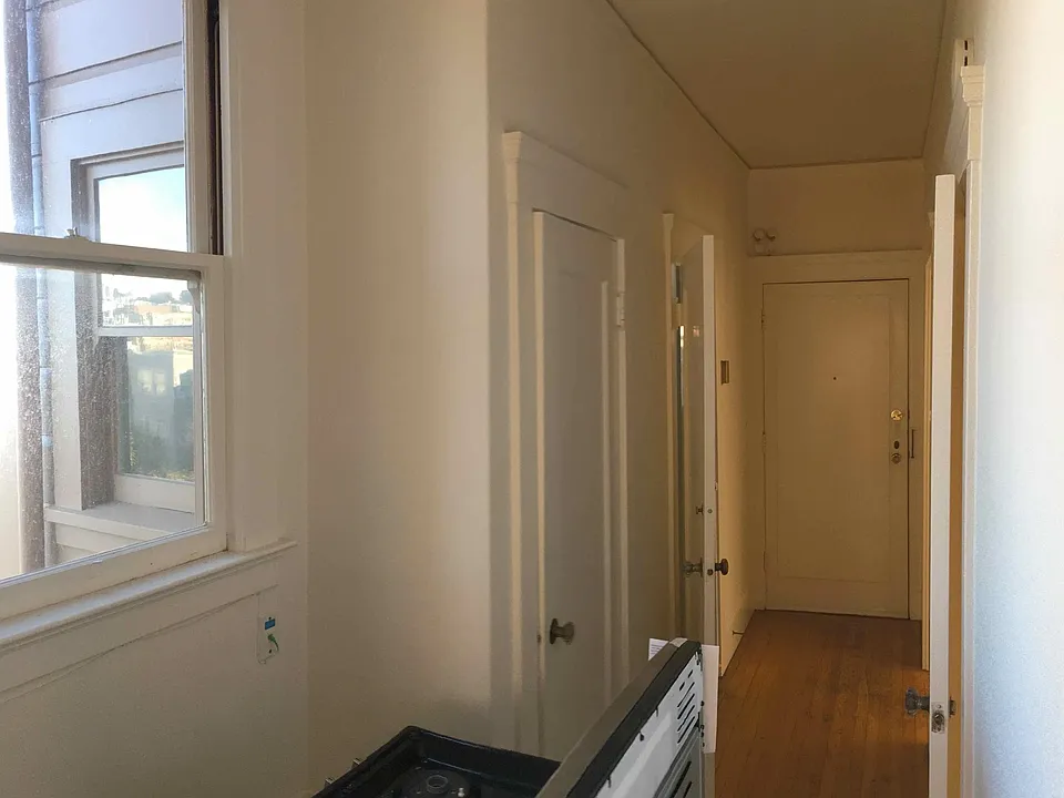 Hallway, with bench, entrance door at end, storage closet (with window) on left,