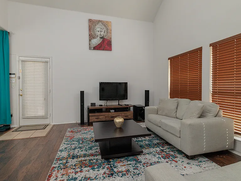 Spacious living room with couch, love seat and TV.